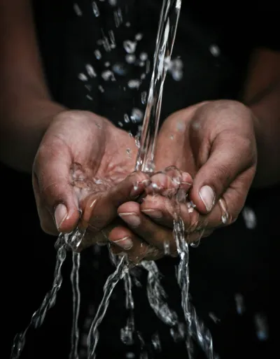 handen die water vangen Een persoon die water vangt met hun handen.